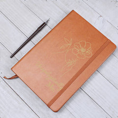 Havijo Unapologetically Me leather journal with textured brown cover and gold-embossed title, open to show lined pages.