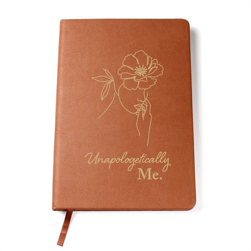 Havijo Unapologetically Me leather journal with a textured brown cover and metal snap closure on a wooden surface.